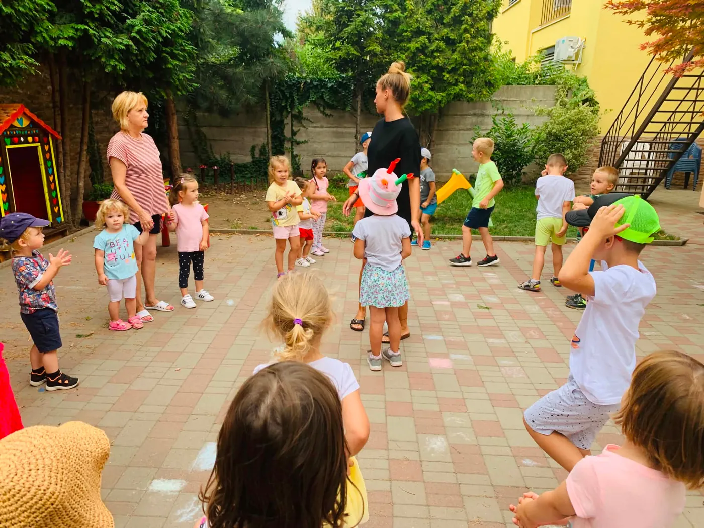 Deti a učiteľky počas rannej rozcvičky na dvore škôlky